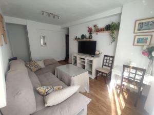 een woonkamer met een bank en een tafel bij piso reformado 3 habitaciones in Sevilla