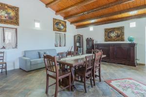 a dining room with a table and chairs and a couch at Casa Furore in Pachino