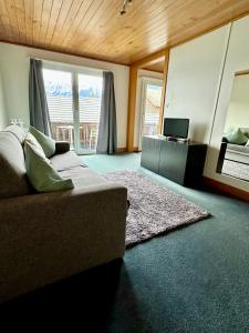 - un salon avec un canapé et un miroir dans l'établissement Eva's Seeblick, à Krattigen