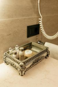 un vassoio d'argento con cosmetici su un bancone del bagno di Weekend Boutique Hotel a Chişinău