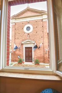 ein Fenster mit Blick auf ein Backsteingebäude mit einer Tür in der Unterkunft 106 Lodge in Siena