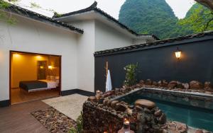 a house with a swimming pool next to a bedroom at Moon Villa in Yangshuo