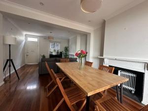 a living room with a wooden table and a fireplace at 3 Bedroom House Family Friendly Surry Hills 2 E-Bikes Included in Sydney