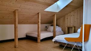 zwei Betten in einem Zimmer mit Holzwänden in der Unterkunft Inovatorių slėnis/ Innovators' valley in Antalieptė