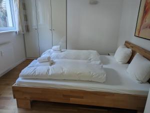 a bed with white sheets and towels on it at Chalet Schloßkopf FeWo Rendl in Sankt Anton am Arlberg