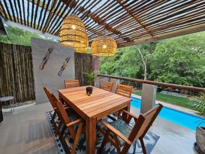 comedor con mesa de madera y sillas en The Blyde Canyon House en Hoedspruit