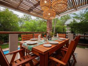 a wooden table with chairs on a patio at The Blyde Canyon House in Hoedspruit