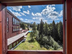 a view from a window of a building with a bench at Belambra Clubs Arc 1800 - Hôtel Du Golf in Arc 1800