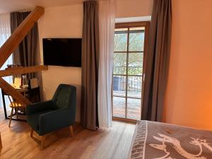 a bedroom with a bed and a chair and a window at Hotel & Glamping Gerhardhof by ALPAMI in Wildermieming