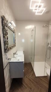 a white bathroom with a sink and a shower at Apartament Jaracza 28 nr 6 in Słupsk