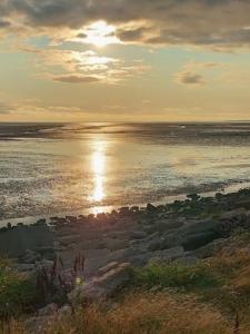 a beach with the sun reflecting on the water at Roadnights Retreat in Heysham