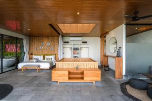 a bedroom with a bed and a tv in a room at The Elementum in Uluwatu