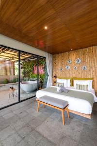 a bedroom with a large bed and a tub at The Elementum in Uluwatu