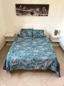 uma cama com um edredão azul num quarto em Bel Appartement en plein cœur de Folelli em Penta-di-Casinca