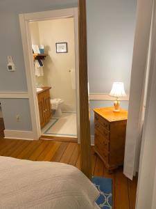 a bedroom with a bathroom with a toilet and a mirror at Spouter Inn Bed & Breakfast in Lincolnville