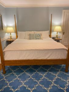 1 dormitorio con 1 cama con 2 lámparas en 2 mesas en Spouter Inn Bed & Breakfast en Lincolnville