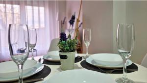 a table with plates and wine glasses on it at Modern & Stylish - Art Atelier Apartment in Skopje