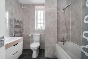 a bathroom with a toilet and a tub and a sink at Lovely 3-bedroom 2 bath duplex flat in SE London in Chislehurst