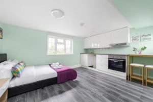 a bedroom with a large bed and a kitchen at Lovely 3-bedroom 2 bath duplex flat in SE London in Chislehurst