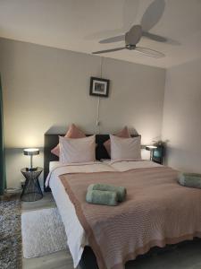 een slaapkamer met een groot bed en een plafondventilator bij Yuki in Zandvoort