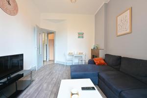 sala de estar con sofá azul y mesa en L'Instant Présent - Appt pour 4 en Charleville-Mézières