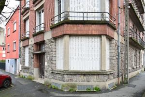 un edificio con una puerta blanca a un lado en L'Instant Présent - Appt pour 4 en Charleville-Mézières