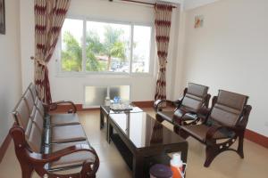a living room with chairs and a table and a window at Coecco Xieng Khouang Hotel in Ban Nafèng