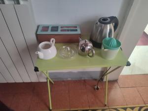 una pequeña mesa verde con ollas y sartenes. en B&B Stella 10, en Nápoles