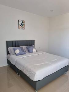1 cama en un dormitorio con una pared blanca en Rest at Thachang Hotel en Ban Hua Han