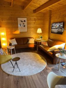 a living room with leather couches and a rug at Luxe en ruim chalet met airco bij Leekstermeer in Matsloot