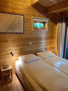 a bedroom with a bed in a wooden cabin at Luxe en ruim chalet met airco bij Leekstermeer in Matsloot
