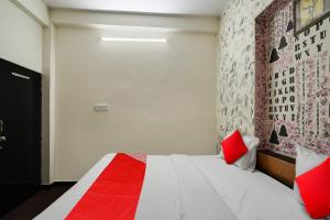 a bedroom with a bed with red pillows and a wall at Flagship Hotel Big Vine in Jaipur