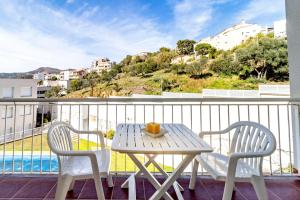 een tafel en stoelen op een balkon met uitzicht bij Cau del Llop 691 Apto con piscina comunitario in Llança