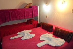 a red bed with towels on top of it at Hotel Antonia in Termas de Río Hondo +68 photos
