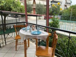 a table and chairs on a balcony with a view of a street at Lovely House with Private Carport & Shady Veranda in Athens