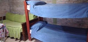 three bunk beds in a room with a brick wall at Casa En Cura Brochero Para Una Familia De 5/6 Pers. Todas las comodidades in Villa Cura Brochero