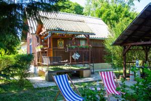 two lawn chairs sitting in front of a house at Pipi Vityilló in Füzérradvány