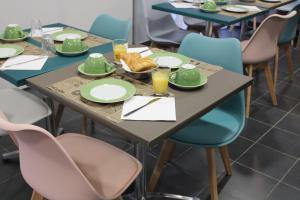 une table avec des assiettes et des verres de jus d'orange dans l'établissement City Lodge Appart Hôtel Niort, à Niort