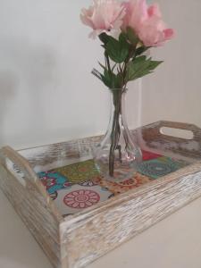un vaso con fiori rosa su un vassoio di Residence S.Cristina a Carmignano