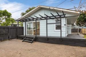 a small white house with a pitched roof at Cozy 3BR West Auckland in Auckland