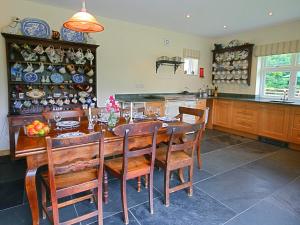 a kitchen with a wooden table with chairs and plates on the wall at Penwaun Nevern in Nevern