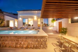 a villa with a swimming pool and a patio at Brand New Villa Carmelita Exclusive with free Smart Car in Dubrovnik +28 photos