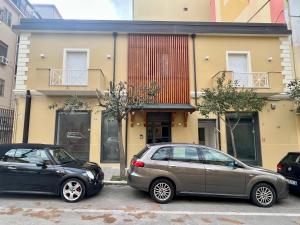 two cars parked in front of a building at AFFITTACAMERE IL TEATRO in Crotone