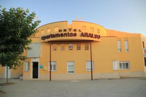 un edificio amarillo con un cartel encima en Hotel Apartamentos Aralso Sotillo, en La Lastrilla