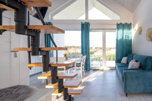 a spiral staircase in a living room with a blue couch at SunHouses - domki nad morzem in Darłowo