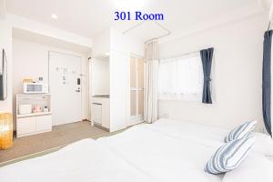 a white bedroom with a bed and a window at UENO station 7min on foot/Cozy Apartment/Convenient location in Tokyo