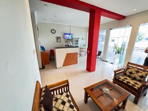 uma sala de estar com cadeiras, uma mesa e um balcão em FAKHIRA RESIDENCE HOTEL em Cianjur