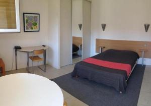 Schlafzimmer mit einem Bett, einem Tisch und einem Schreibtisch in der Unterkunft Résidence Hôtel Residella in Gémenos