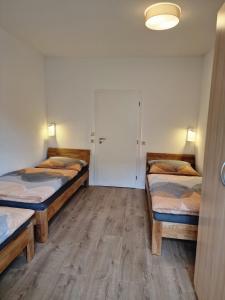 two beds in a room with wooden floors at Vermietung D&S in Kapfenberg