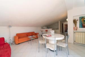 sala de estar con sofá, mesa y sillas en Appartamenti Villa Innamorata, en Capoliveri